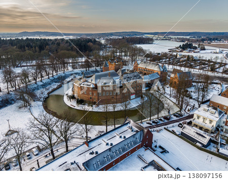 Detailed aerial view of Huis Bergh Castle in winter. Historical medieval brick fortress surrounded by a frozen circular moat and snow covered grounds in a picturesque European town landscape. Detailed aerial view of Huis Bergh Castle in winter. Historical medieval brick fortress surrounded by a frozen circular moat and snow covered grounds in a picturesque European town landscape. 138097156