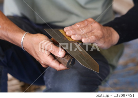 左官コテの手入れをする男性 138097451
