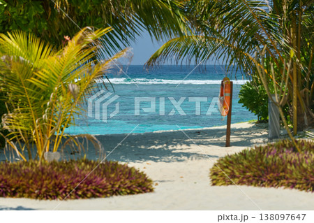 Classic Maldives island landscape on a sunny day, coastal luxury resort buildings, azure water, white sand, palm trees on the shore Classic Maldives island landscape on a sunny day, coastal luxury resort buildings, azure water, white sand, palm trees on the shore 138097647