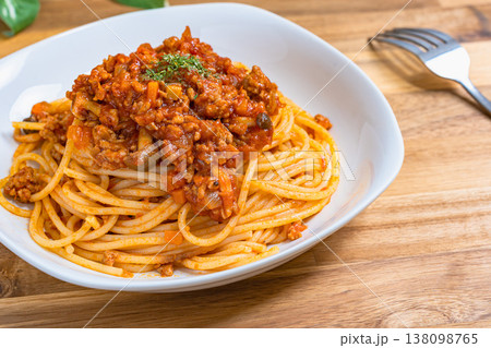 ミートソースパスタ 白い皿に盛り付けたボロネーゼ 木目テーブルの洋食イメージ ミートソースパスタ 白い皿に盛り付けたボロネーゼ 木目テーブルの洋食イメージ 138098765
