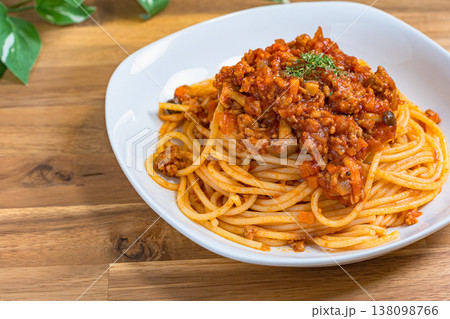 ミートソースパスタ 白い皿に盛り付けたボロネーゼ 木目テーブルの洋食イメージ ミートソースパスタ 白い皿に盛り付けたボロネーゼ 木目テーブルの洋食イメージ 138098766