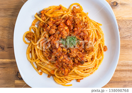 ミートソースパスタ 白い皿に盛り付けたボロネーゼ 木目テーブルの洋食イメージ ミートソースパスタ 白い皿に盛り付けたボロネーゼ 木目テーブルの洋食イメージ 138098768
