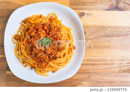 ミートソースパスタ 白い皿に盛り付けたボロネーゼ 木目テーブルの洋食イメージ ミートソースパスタ 白い皿に盛り付けたボロネーゼ 木目テーブルの洋食イメージ 138098770