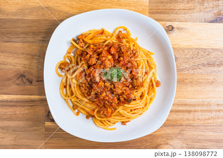 ミートソースパスタ 白い皿に盛り付けたボロネーゼ 木目テーブルの洋食イメージ ミートソースパスタ 白い皿に盛り付けたボロネーゼ 木目テーブルの洋食イメージ 138098772
