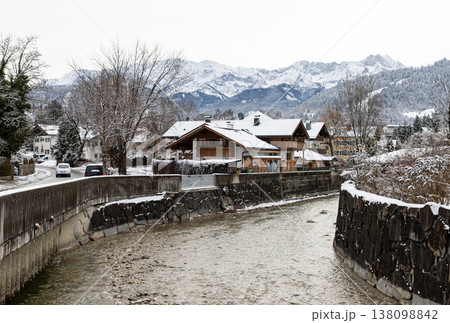 Alpine canal bend and village houses in winter 138098842