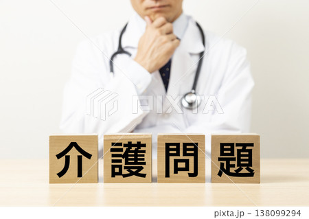 「介護問題」と書かれたブロックと悩む医師 「介護問題」と書かれたブロックと悩む医師 138099294