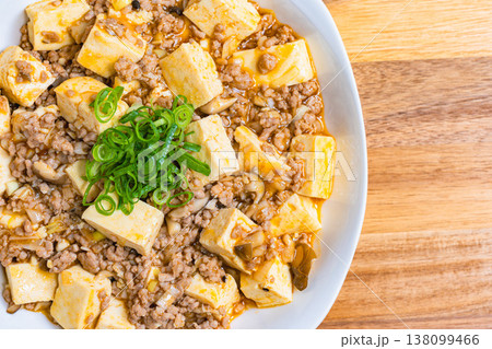 麻婆豆腐 白い皿に盛り付けた中華料理 木目テーブルの家庭料理 麻婆豆腐 白い皿に盛り付けた中華料理 木目テーブルの家庭料理 138099466