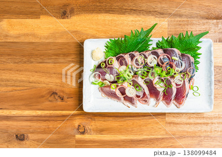 鰹のたたきの盛り付け 薬味をのせた和食の刺身料理 木目テーブル 鰹のたたきの盛り付け 薬味をのせた和食の刺身料理 木目テーブル 138099484