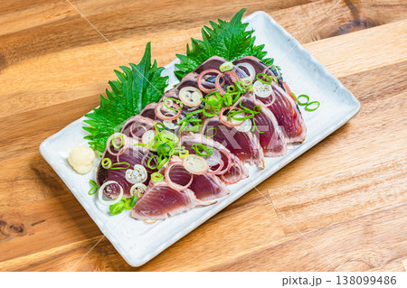 鰹のたたきの盛り付け 薬味をのせた和食の刺身料理 木目テーブル 138099486