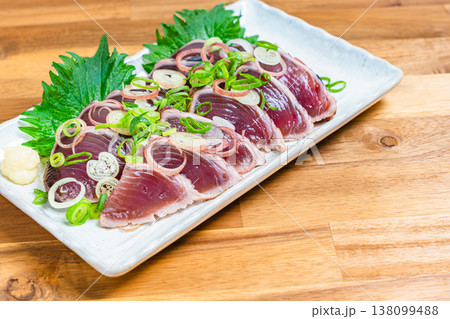 鰹のたたきの盛り付け 薬味をのせた和食の刺身料理 木目テーブル 138099488