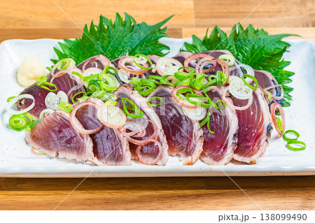 鰹のたたきの盛り付け 薬味をのせた和食の刺身料理 木目テーブル 鰹のたたきの盛り付け 薬味をのせた和食の刺身料理 木目テーブル 138099490