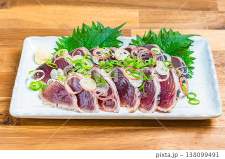 鰹のたたきの盛り付け 薬味をのせた和食の刺身料理 木目テーブル 鰹のたたきの盛り付け 薬味をのせた和食の刺身料理 木目テーブル 138099491