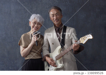 シニアのミュージシャン 男性のギタリストと女性のボーカル 黒背景 カメラ目線 シニアのミュージシャン 男性のギタリストと女性のボーカル 黒背景 カメラ目線 138099526
