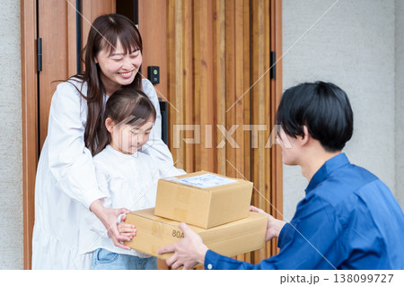 荷物を受け取る女の子とお母さん 荷物を受け取る女の子とお母さん 138099727
