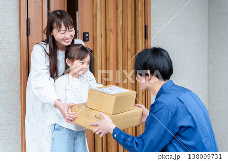 荷物を受け取る女の子とお母さん 荷物を受け取る女の子とお母さん 138099731