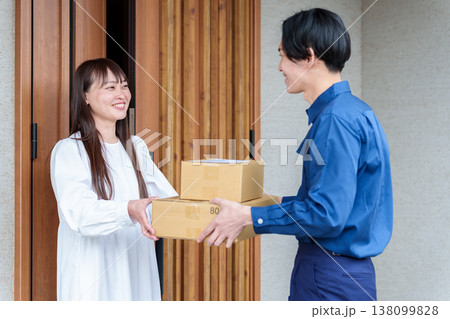 配達員の荷物を受け取る女性 138099828