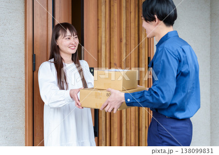 配達員の荷物を受け取る女性 配達員の荷物を受け取る女性 138099831