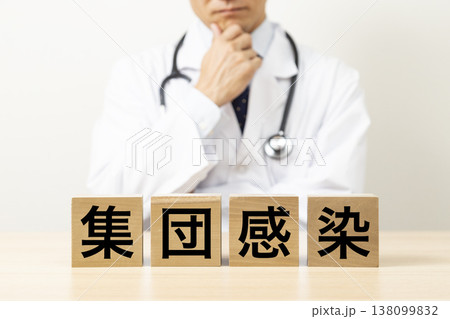 「集団感染」と書かれたブロックと悩む医師 138099832