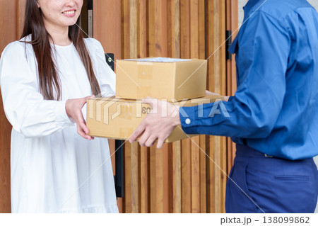 配達員の荷物を受け取る女性 配達員の荷物を受け取る女性 138099862