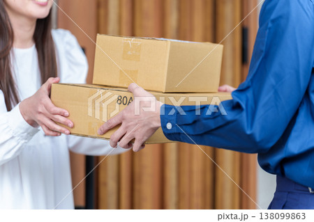 配達員の荷物を受け取る女性 配達員の荷物を受け取る女性 138099863