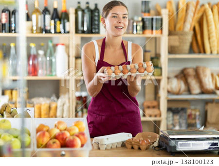 Friendly girl selling food products offers to buy chicken eggs 138100123