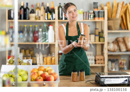 Young female seller offering lentils in grocery store Young female seller offering lentils in grocery store 138100138