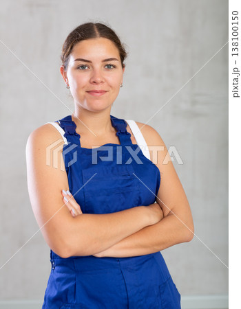Happy female worker in work clothes standing and smiling with pride 138100150