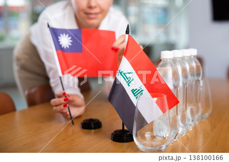 Preparing for business presentation - secretary places flags of Iraq and Taiwan on negotiating table 138100166