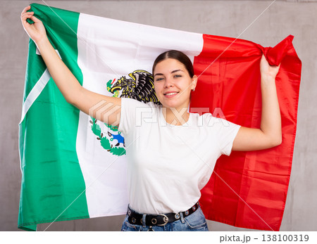 Happy girl stands with flag of Mexicо. Isolated on gray background 138100319