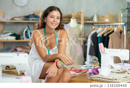 dressmaker playfully poses in the workshop 138100448