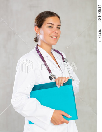 Happy female doctor standing with file in hands 138100634