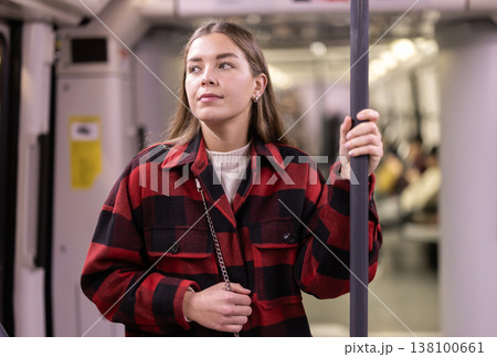Girl is standing in subway car, getting to work Girl is standing in subway car, getting to work 138100661