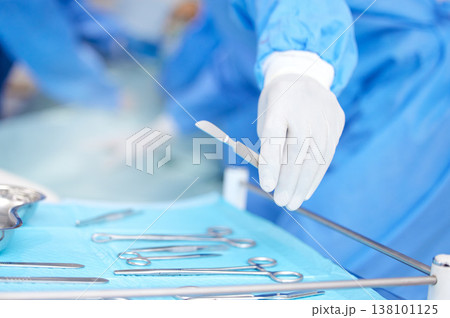 Hand, surgeon and metal tools for surgery in hospital, medical treatment and healthcare with help. Doctor person with equipment for procedure, scalpel and scissors, health and closeup for operation Hand, surgeon and metal tools for surgery in hospital, medical treatment and healthcare with help. Doctor person with equipment for procedure, scalpel and scissors, health and closeup for operation 138101125