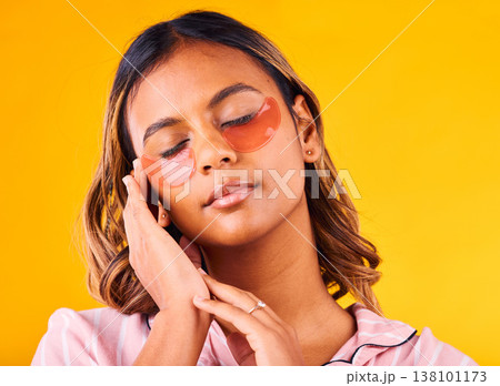 Woman, eye mask and beauty with skincare, dermatology and cosmetic product on yellow background. Peace, calm and self care treatment with patch, facial for antiaging with glow and wellness in studio Woman, eye mask and beauty with skincare, dermatology and cosmetic product on yellow background. Peace, calm and self care treatment with patch, facial for antiaging with glow and wellness in studio 138101173