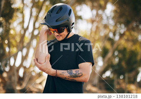 Cycling, arm injury and a sports man in the forest for fitness, training or adrenaline with pain from an accident. Exercise, emergency and a young athlete or rider in the woods for a race or workout 138101218