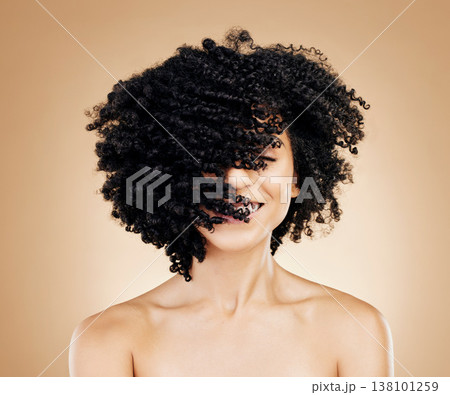 Woman, curly and hair wind in afro fun on studio background for healthy hairstyle growth, texture and frizz treatment. African beauty model, shake energy and change by shampoo transformation results 138101259