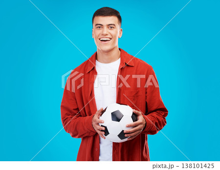 Soccer ball, happy and portrait of man on blue background for sports, winner and achievement. Smile, football fan and person cheer for team success, winning match, game and tournament in studio 138101425