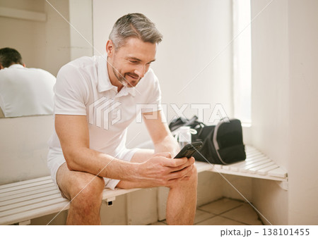 Tennis, phone and man typing on social media after exercise, workout or training in a sports club change room. Smile, connection and athlete chatting on mobile app for communication online or web Tennis, phone and man typing on social media after exercise, workout or training in a sports club change room. Smile, connection and athlete chatting on mobile app for communication online or web 138101455