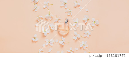 Perfume bottle and delicate flowers white petals pink background flat layout. Flower water floral natural background  138101773