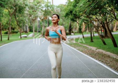 Young runner Asian woman jogging in park path, skinny fit in sports wear outfit leggings and top Young runner Asian woman jogging in park path, skinny fit in sports wear outfit leggings and top 138102450
