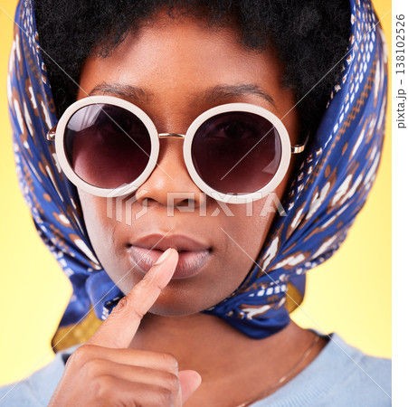 Fashion, silence and sunglasses with portrait of black woman in studio for vintage, secret and beauty. Mystery, whisper and rumor with person and scarf on yellow background for frames and style 138102526