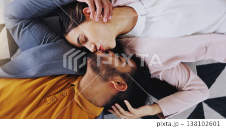 Embrace, above and couple kiss on the floor for love, care and comfort in relationship. Happy, affection and a man and woman kissing for happiness, marriage and romance together with a smile 138102601