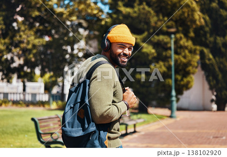 Portrait, outdoor and man with headphones, streaming music and connection with radio, sunshine and listening to audio. Face, person or student with a backpack, headset and podcast with sound or gen z 138102920