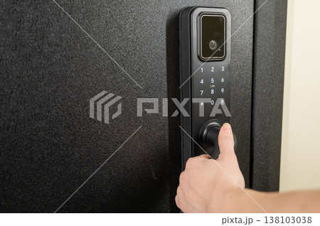 A woman opens a modern smart door lock with a digital keypad and biometric fingerprint access. 138103038