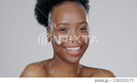Black woman, face and cream with beauty, skincare and healthy skin for portrait, moisturizer and blue studio background. Happy, female and sunscreen for dermatology, cosmetology and luxury product Black woman, face and cream with beauty, skincare and healthy skin for portrait, moisturizer and blue studio background. Happy, female and sunscreen for dermatology, cosmetology and luxury product 138103173