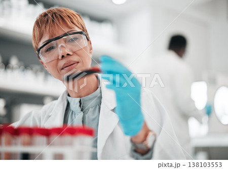 Woman, scientist and blood sample in lab, ideas and analysis with ppe glasses, safety and test. Science, pathology and expert with thinking, inspection and dna data for medical research in laboratory Woman, scientist and blood sample in lab, ideas and analysis with ppe glasses, safety and test. Science, pathology and expert with thinking, inspection and dna data for medical research in laboratory 138103553