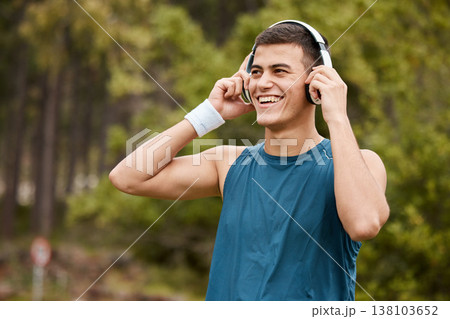 Fitness, headphones and a man outdoor listening to music or audio with wellness. Happy runner, athlete or sports person in nature park to start exercise, workout or training while streaming radio 138103652