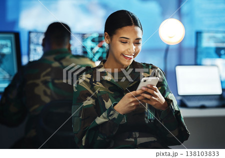 Phone, military and woman soldier in the control room in uniform for war or battle networking. Happy, smile and young female army warrior typing a message on internet with cellphone for surveillance. 138103833