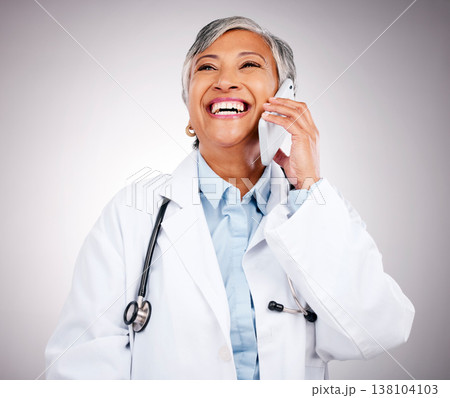 Doctor, phone call and woman in studio for communication, consulting or telehealth contact on grey background. Happy mature medical surgeon laugh for mobile consultation, support or healthcare advice 138104103