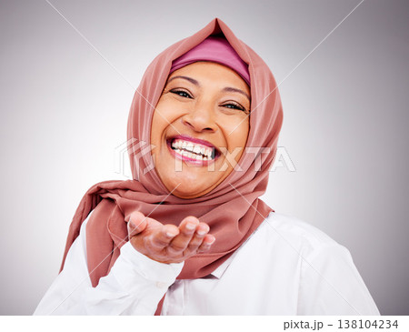 Blow kiss, happy and portrait of Muslim woman in studio with makeup, cosmetics and beauty. Fashion, style and face of Islamic person with hand gesture for love, affection or emoji on gray background 138104234